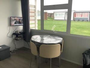 a table and two chairs in a room with a window at 245 Sundowner in Hemsby