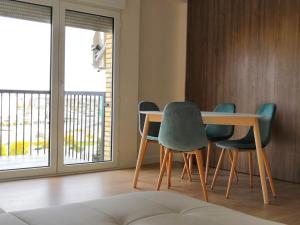 a dining room with a table and four chairs at La Parada de la Estacion con parking in Zaragoza