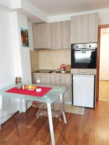 La cuisine est équipée d'une table, d'une cuisinière et d'un réfrigérateur. dans l'établissement Stan na dan Loznica, à Loznica