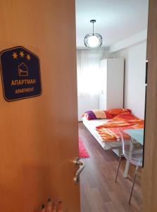 a bedroom with a bed and a door with a sign at Stan na dan Loznica in Loznica