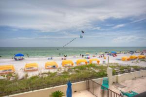 a beach with yellow umbrellas and people on the beach at 106 - Kima in St. Pete Beach