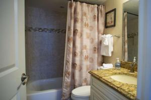 a bathroom with a sink and a toilet and a shower at 106 - Kima in St. Pete Beach