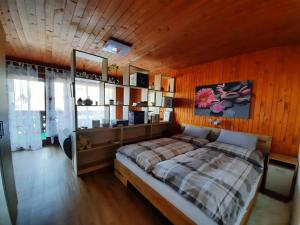 a bedroom with a bed and a wooden wall at Snežak (Snowman) 2 in Bohinj