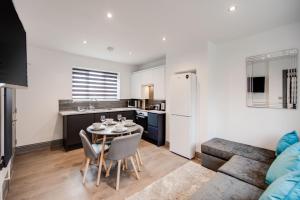 a kitchen and living room with a table and chairs at Central location ideal for contractors, families and business travellers in Ashford