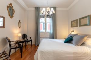 a bedroom with a bed and a desk and a chandelier at 2MAYO by Kyosai in Bilbao