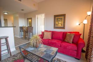 ein rotes Sofa im Wohnzimmer mit einem Tisch in der Unterkunft 409 - Madeira Bay Resort in St Pete Beach