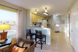 a living room with a kitchen with chairs and a bar at 206 - Surf Beach Resort in St. Pete Beach
