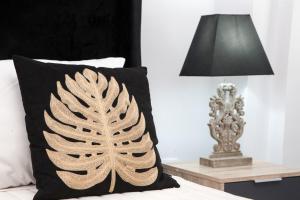 a pillow on a bed next to a lamp at Georgia Pelekanou Studios in Fira +91 photos
