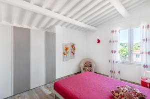 een slaapkamer met een roze bed en een raam bij Elena in Marina di Campo
