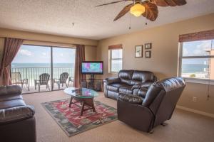 een woonkamer met lederen meubels en uitzicht op de oceaan bij 408 - Sea Breeze in St Pete Beach