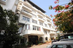 a white building with windows and cars parked in front of it at Pension Vasana Hotel in Kathmandu