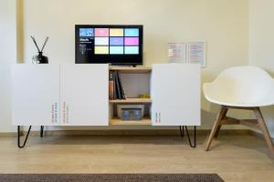 two white cabinets in a room with a tv and a chair at Apartamento Escapada in Andorra la Vella