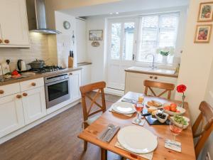 une cuisine avec une table en bois et des chaises ainsi qu'une salle à manger dans l'établissement Dove Cottage, à Pickering 8 autres photos