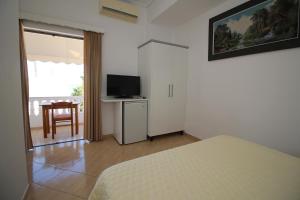 a bedroom with a bed and a television and a table at Julia Hotel in Sarandë