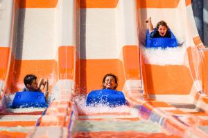 a group of people riding on a water slide at Hard Rock Hotel Riviera Maya - All Inclusive in Puerto Aventuras
