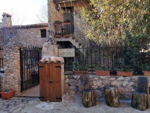un edificio de piedra con una puerta y un árbol en Casas Rurales el Olmo, en Riópar Viejo