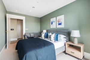a bedroom with a large bed with a blue blanket at Luxury River View Greenwich Apartment in London