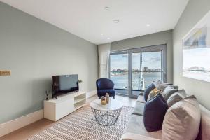 a living room with a couch and a tv at Luxury River View Greenwich Apartment in London