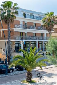a palm tree in front of a building at Hotel Dino in San Benedetto del Tronto