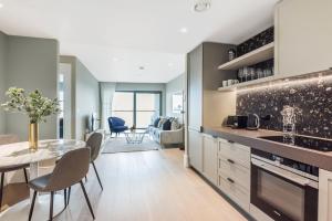 a kitchen and dining room with a table and chairs at Luxury River View Greenwich Apartment in London