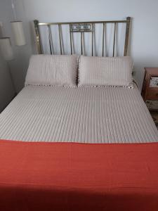a bed with a red and white blanket on it at La Casita in Garzón