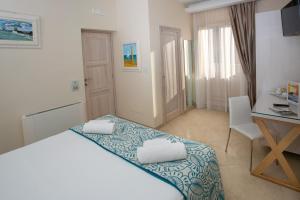 - une chambre avec un lit, un bureau et une table dans l'établissement Residenza Donna Giovanna, à Tropea
