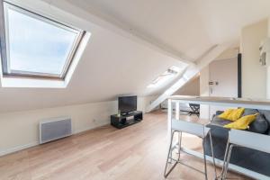 a living room with a large window and a couch at APARTEO Studio - Gare RER à 3min - Paris 17min in Aulnay-sous-Bois
