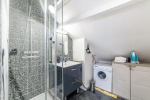 a bathroom with a shower and a washing machine at APARTEO Studio - Gare RER à 3min - Paris 17min in Aulnay-sous-Bois +30 photos