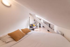 a white bedroom with a bed and a staircase at APARTEO Studio - Gare RER à 3min - Paris 17min in Aulnay-sous-Bois