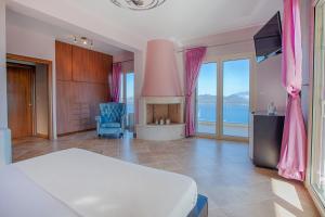 a bedroom with a bed and a fireplace with pink curtains at Villa Ventalia in Nikiana +40 photos