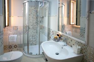 uma casa de banho com um lavatório, um chuveiro e um WC. em Residenza Donna Giovanna em Tropea