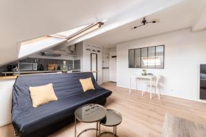 a living room with a bed and a table at APARTEO Studio - Gare RER à 3min - Paris 17min in Aulnay-sous-Bois