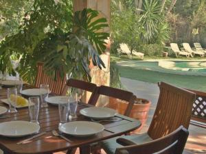 - une table en bois avec des assiettes et des verres sur la terrasse dans l'établissement Belvilla by OYO Casa Jaume, à San Pol de Mar