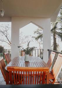 a wooden table with chairs on a porch at Casa de campo Villares in Dosbarrios