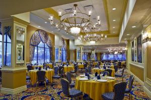 a banquet hall with tables and chairs and a chandelier at Villa Roma Resort and Conference Center in Callicoon