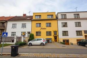 a white car parked in front of a yellow building at Pension Fontana in Poděbrady