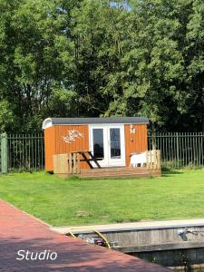 a tiny house sitting in the grass next to a fence at Marinaparcs Naarden in Naarden