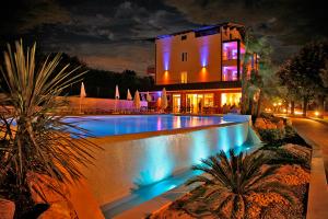 una grande casa con piscina di notte di Hotel San Vito a Bardolino