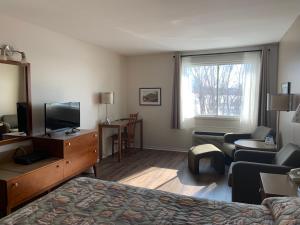 ein Hotelzimmer mit einem Bett und einem TV in der Unterkunft Hotel Transit in Mont-Saint-Hilaire