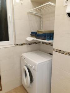 una lavatrice e asciugatrice bianche in bagno di Madana apartman a Budapest