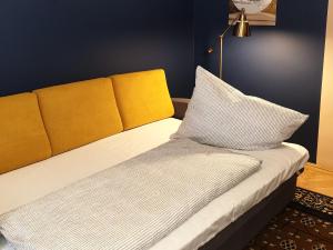 a bed with a yellow headboard and two pillows at Madana apartman in Budapest