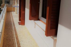 a hallway of a building with brown doors and a window at Ellis Apartments , Amperia , Crete in Chania Town
