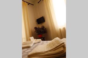 a bedroom with a bed with white sheets and a plant at Ellis Apartments , Amperia , Crete in Chania Town