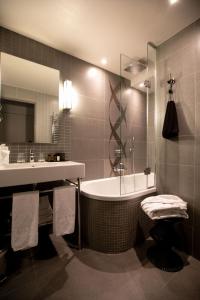 a bathroom with a sink, toilet and bathtub at Le Grey Hotel in Paris