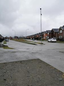 an empty street with houses and a white car parked at Casa Amoblada Puerto Montt in Puerto Montt