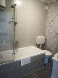 a bathroom with a bath tub and a toilet at Apartment Mare in Crikvenica