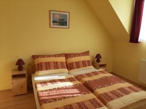 1 dormitorio con 1 cama con 2 almohadas en Kondics Apartmanház, en Sárvár