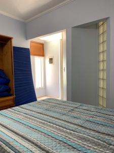 een slaapkamer met een groot bed met een blauwe muur bij CASA PÔR DO SOL 2 in Arraial do Cabo