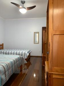1 Schlafzimmer mit 2 Betten und einem Deckenventilator in der Unterkunft CASA PÔR DO SOL 2 in Arraial do Cabo