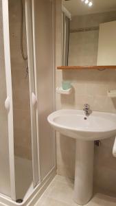 un bagno bianco con lavandino e doccia di Residenza Trevisani a Bari